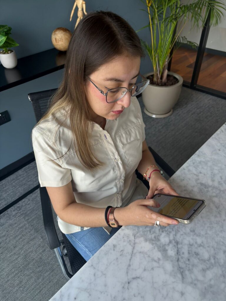 Sol looking at resource on her phone, from the Global Deafblindness Resource Hub